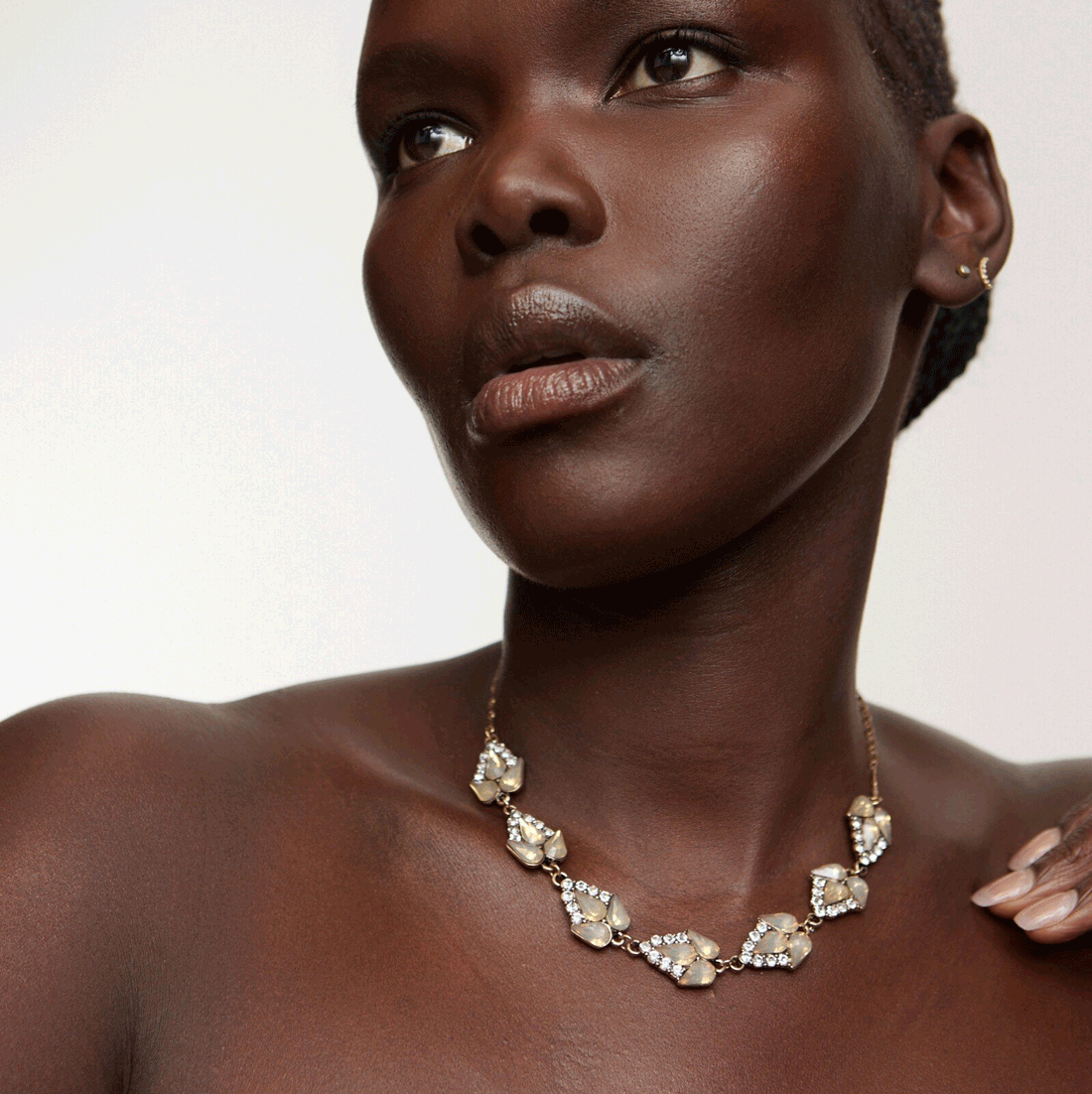 A gold curb chain necklace with a clasp fastening