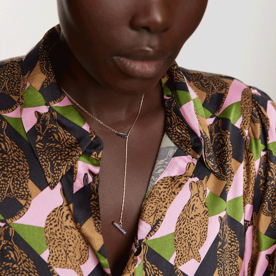 A gold drop necklace with two purple gems